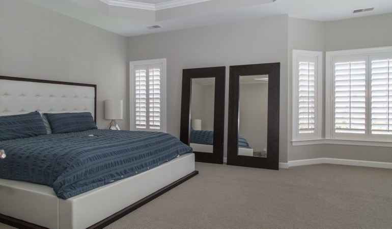 White shutters in a minimalist bedroom in Virginia Beach.